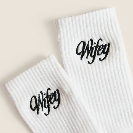 White socks with 'Wifey' text on a light pink background