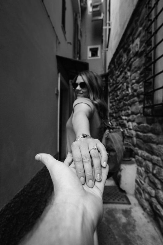 Woman's hand with engagement ring, holding males hand.