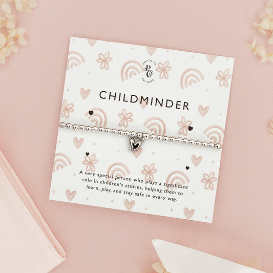 Personalised silver beaded bracelet with a heart charm for childmider, displayed on a custom card with heart illustrations, set against a pink background.