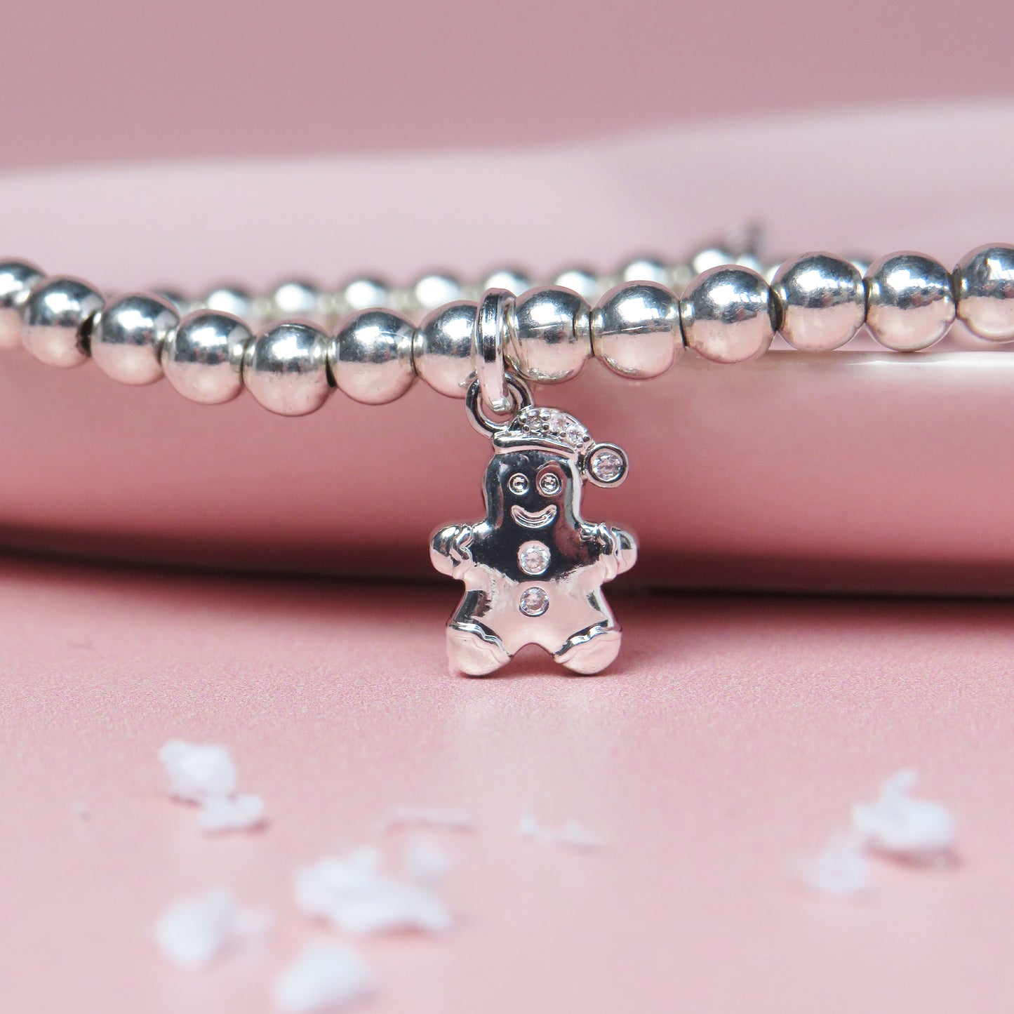 Silver-plated gingerbread man charm bracelet on a festive "Merry Little Christmas" card with gingerbread illustrations, perfect for holiday gifts and stocking fillers.