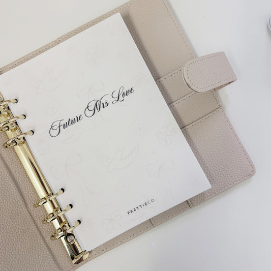 Beige planner with a white card inside reading 'Future Mrs". Perfect engagement gift.